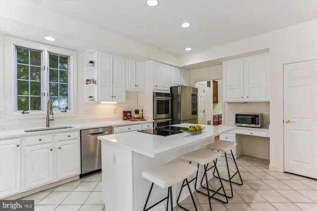 a kitchen with white cabinets and window