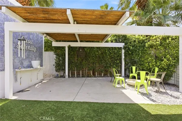a view of a patio with couches plants and large tree