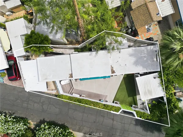 an aerial view of a house with a yard and large trees