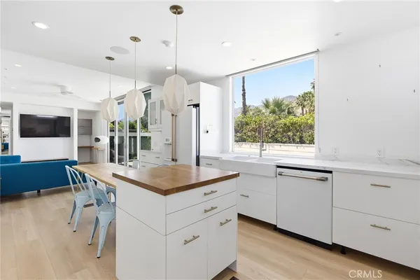 a kitchen with a sink window and chairs