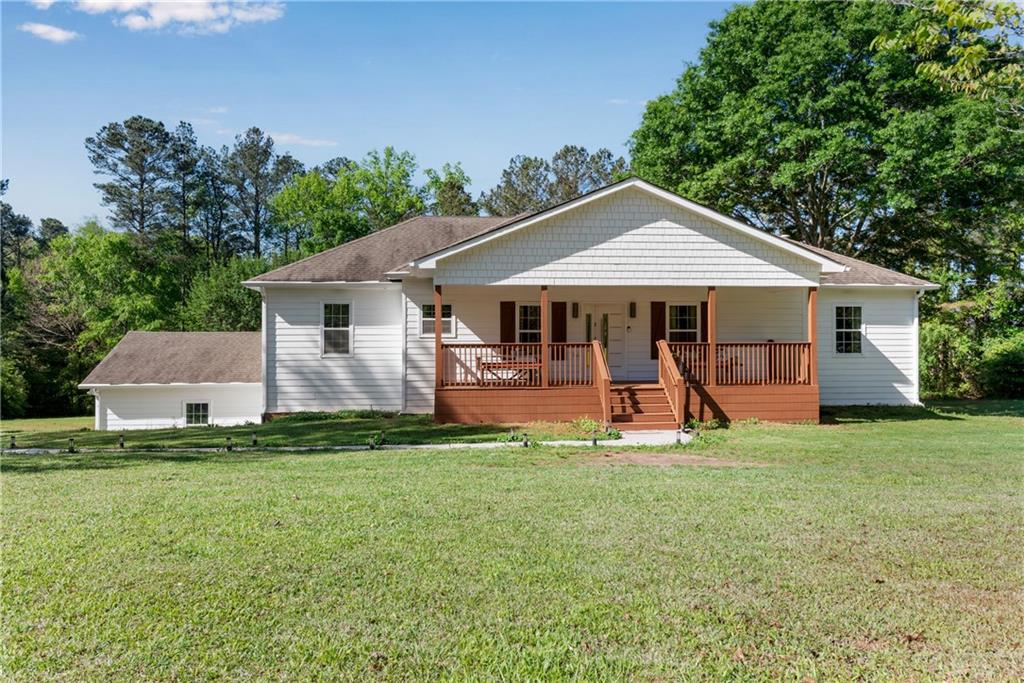 a view of a house with a yard and sitting area