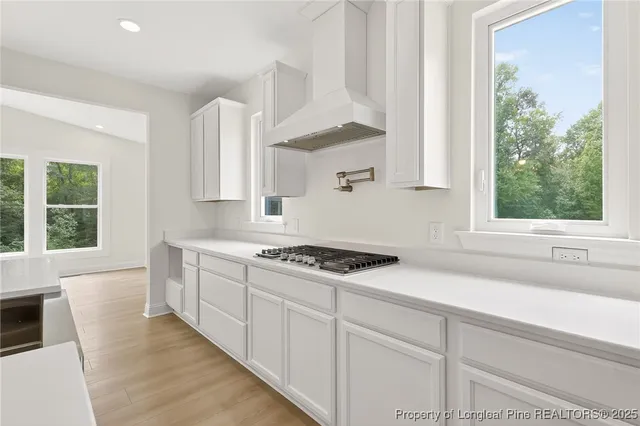 a kitchen with white cabinets and a stove top oven