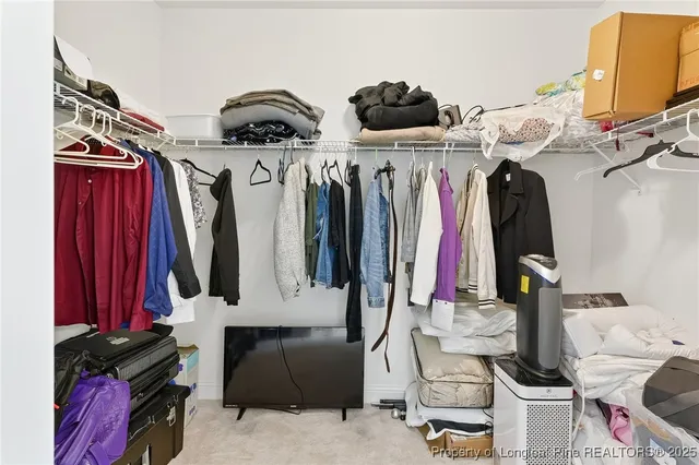 a view of walk in closet with clothes and shoes