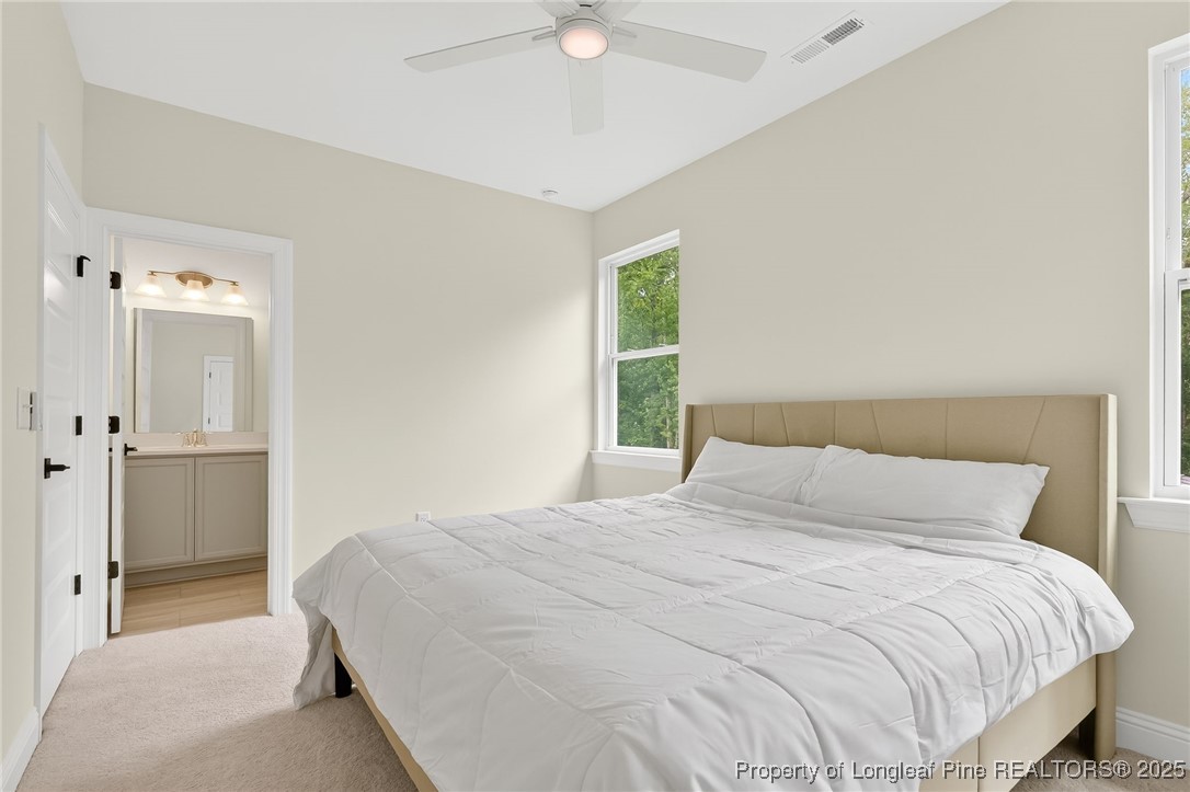 197 Silverside Drive Angier, NC 27501 - Photo 39 of 48 a bedroom with a bed and a chandelier