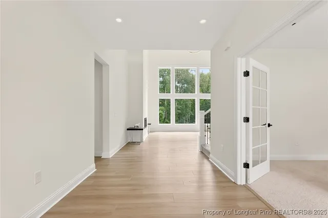a view of a hallway with wooden floor and windows