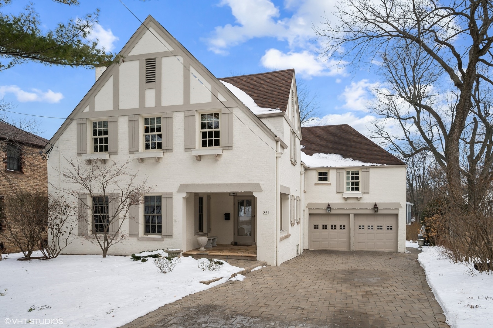 221 Church Road Winnetka, IL 60093 - Photo 3 of 42 a view of a white house with a yard with plants and a large tree