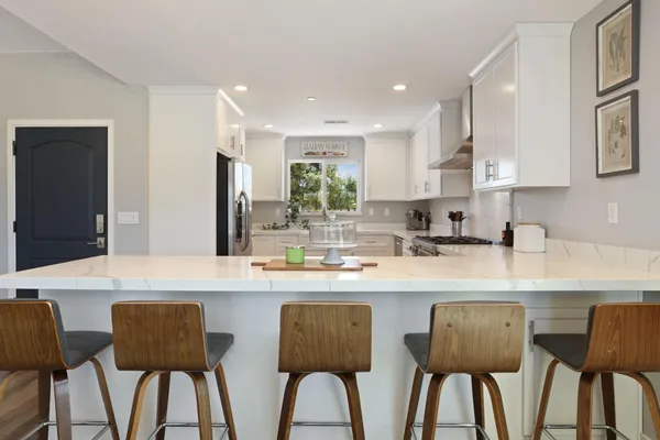 a kitchen with a stove a sink and a granite counter tops