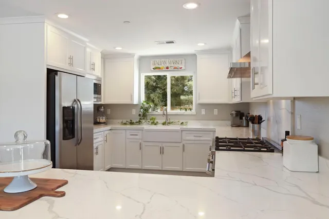 a kitchen with white cabinets and stainless steel appliances