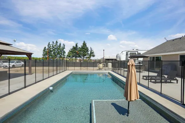 a swimming pool with outdoor seating and yard