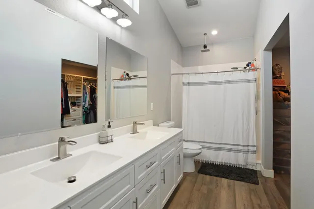 a en suite bathroom with double sink a large mirror and vanity