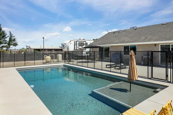a swimming pool with outdoor seating and yard