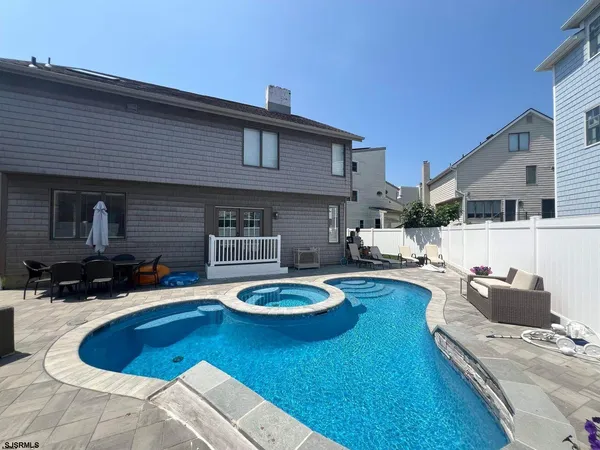 a view of a hallway to a livingroom with wooden floor and furniture
