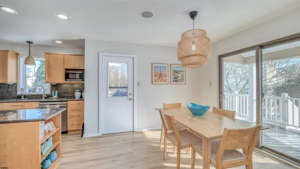 a living room with furniture a chandelier and a dining table with wooden floor