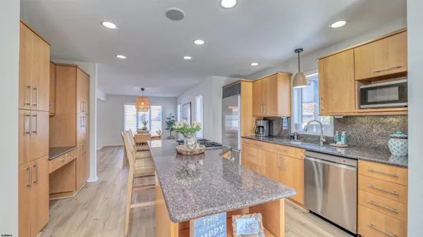 a kitchen with stainless steel appliances granite countertop a refrigerator a stove and a wooden floors