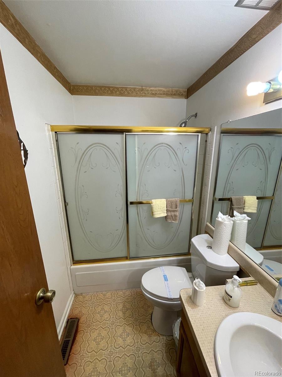 4841 Carson Street Denver, CO 80239 - Photo 6 of 12 a bathroom with a sink mirror vanity and toilet