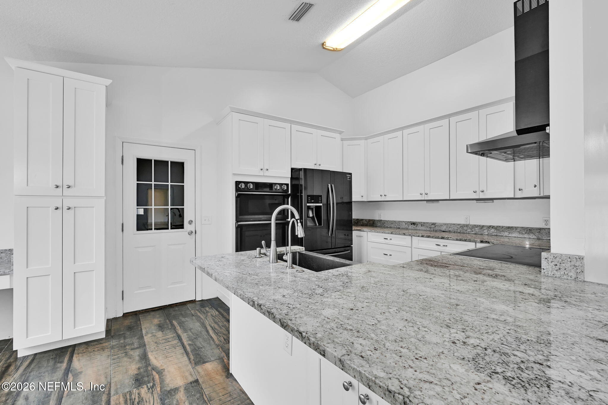 1110 Woodlawn Road, Unit D St. Augustine, FL 32084 - Photo 24 of 40 a kitchen with granite countertop a sink a stove and a wooden floors