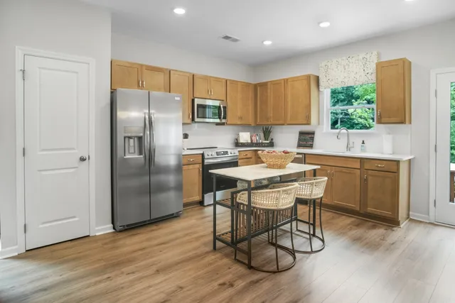 a kitchen with a table chairs refrigerator microwave and cabinets