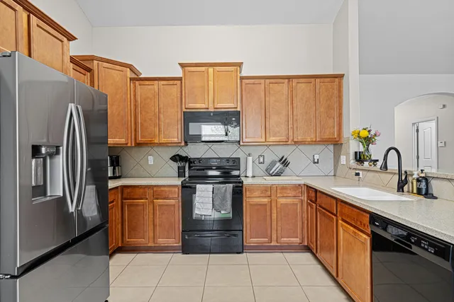 a kitchen with stainless steel appliances granite countertop a refrigerator sink and cabinets