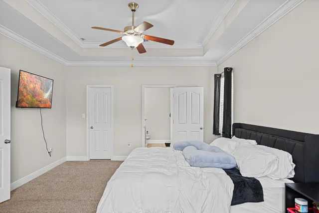 a bedroom with a large bed and a chandelier