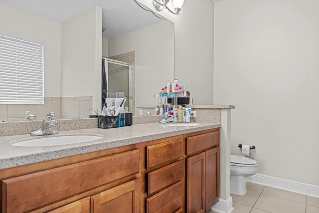a bathroom with a granite countertop sink a toilet and a mirror