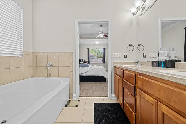 a bathroom with a tub sink and mirror