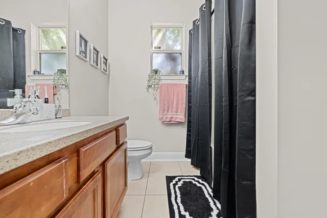 a bathroom with a sink a toilet a mirror and shower