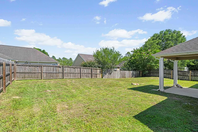 a view of a backyard with swimming pool and seating space
