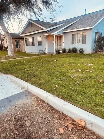 a front view of a house with a yard and trees