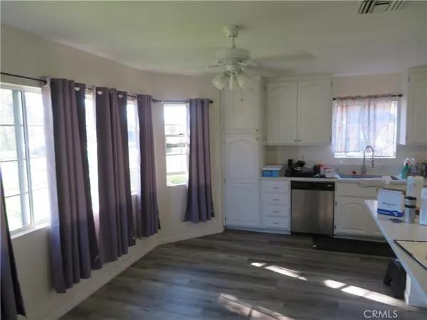 a kitchen with granite countertop a stove a sink dishwasher and a refrigerator with wooden floor