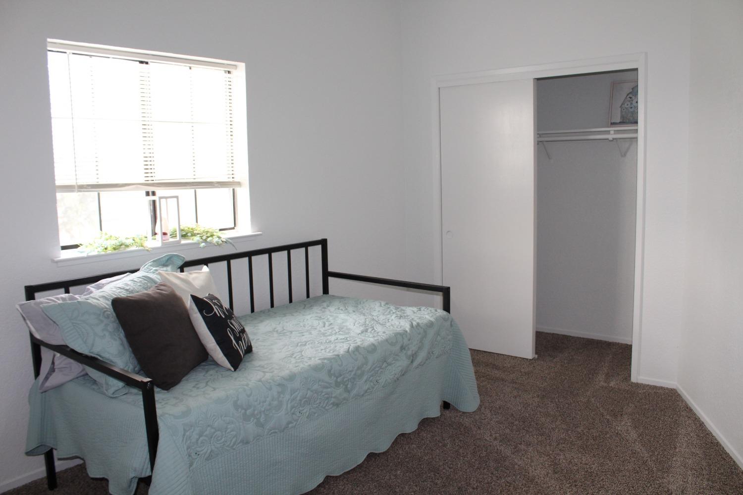 13431 South Henderson Road Caruthers, CA 93609 - Photo 12 of 14 a bed sitting in a bedroom next to a window