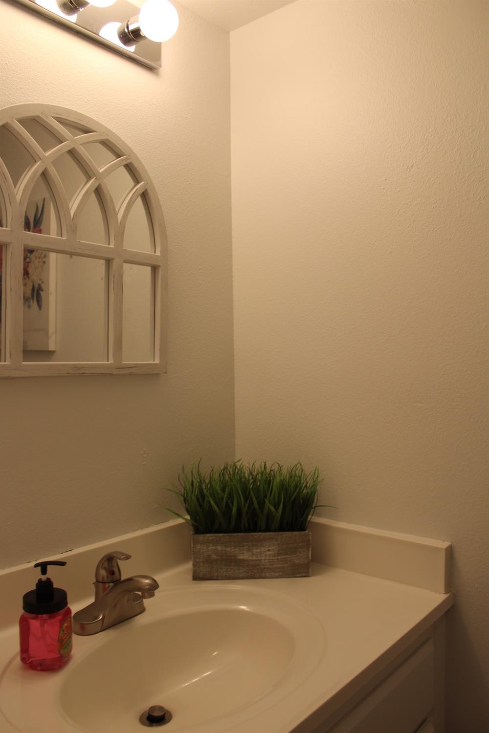13431 South Henderson Road Caruthers, CA 93609 - Photo 14 of 14 a bathroom with a sink and mirror with bathtub