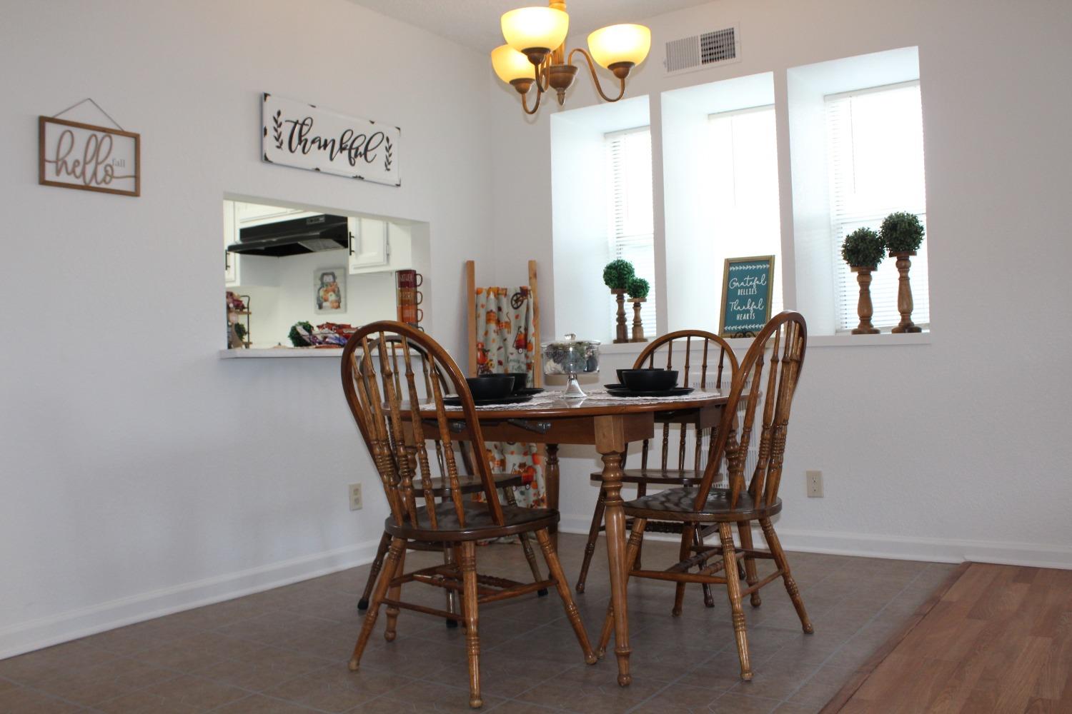 13431 South Henderson Road Caruthers, CA 93609 - Photo 5 of 14 a view of a dining room with furniture a chandelier and wooden floor