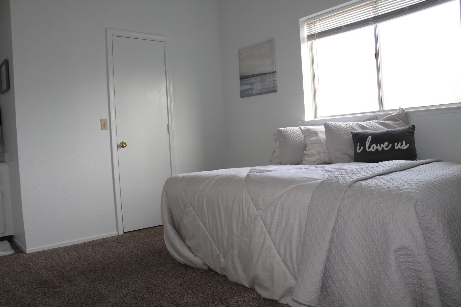 13431 South Henderson Road Caruthers, CA 93609 - Photo 9 of 14 a bedroom with a bed and a window