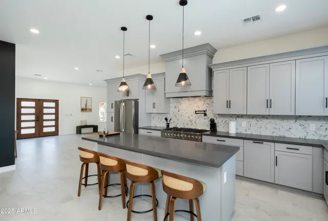 a kitchen with counter space sink stove and living room view