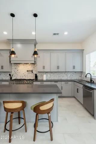 a kitchen with granite countertop a sink stove and cabinets