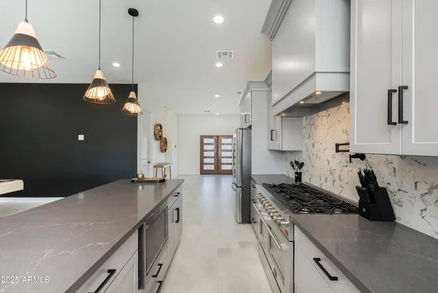 a kitchen with granite countertop a stove sink and cabinets