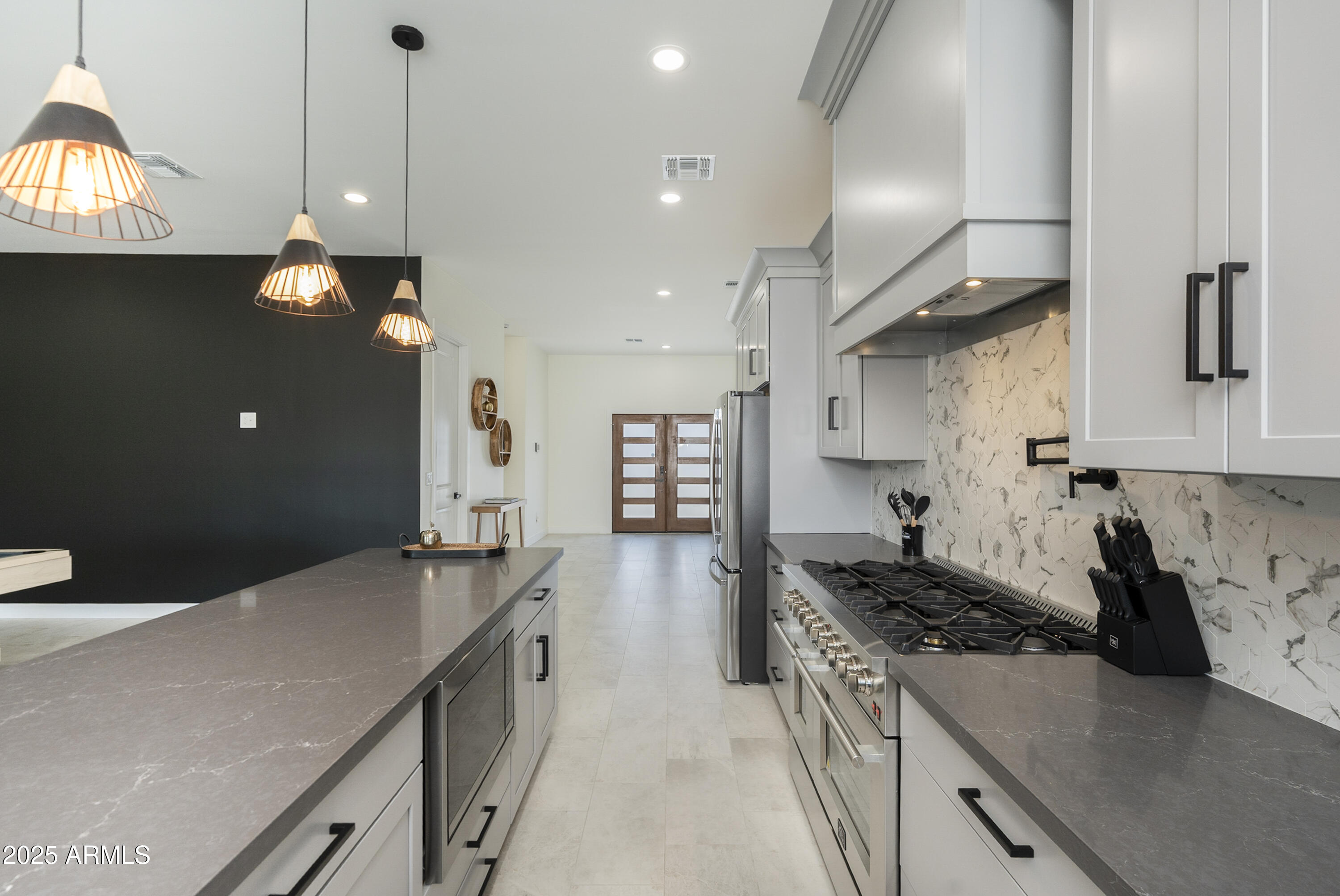 5049 East Shaw Butte Drive Scottsdale, AZ 85254 - Photo 15 of 88 a kitchen with a stove and a chandelier