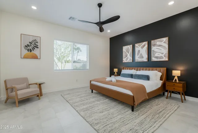 a bedroom with a bed and painting on the wall