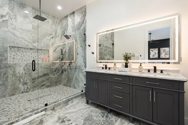 a kitchen with stainless steel appliances kitchen island granite countertop a sink and a black cabinets