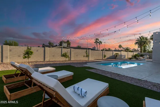 a kitchen with stainless steel appliances granite countertop white cabinets and chairs
