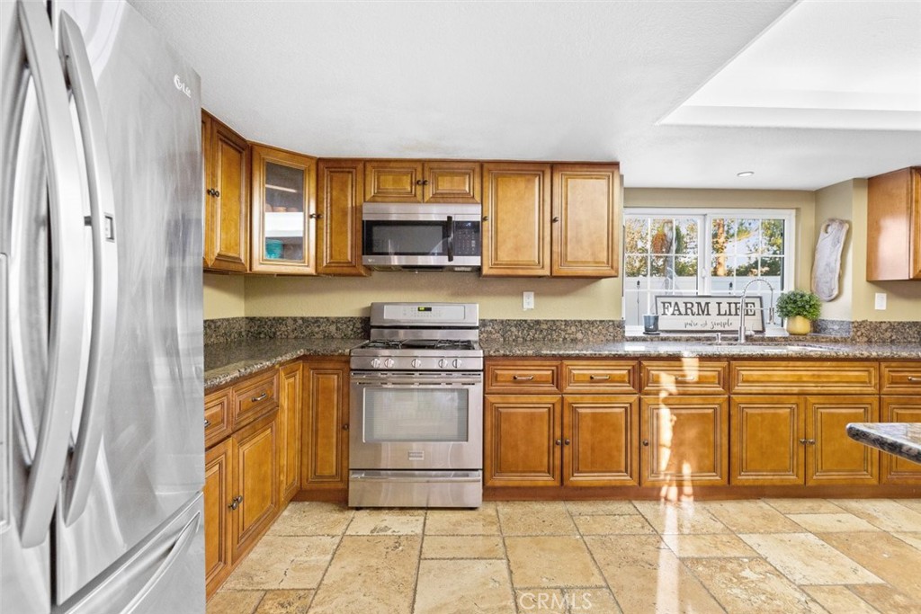 25010 Foxtail Court Stevenson Ranch, CA 91381 - Photo 27 of 64 a kitchen with stainless steel appliances granite countertop a stove a sink and a microwave