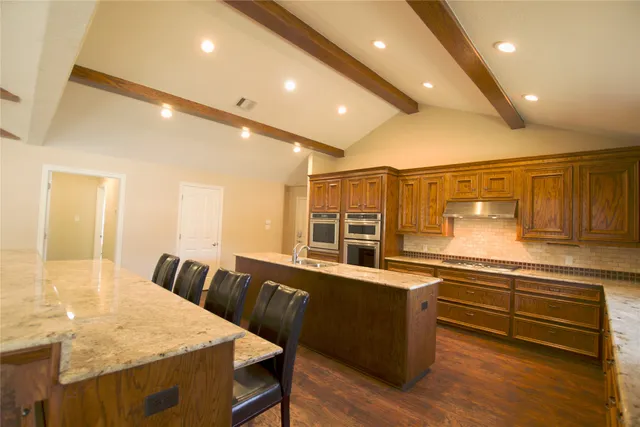 a large kitchen with lots of counter space and wooden floor