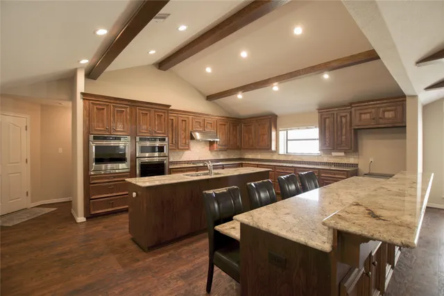 a large kitchen with lots of counter space and stainless steel appliances