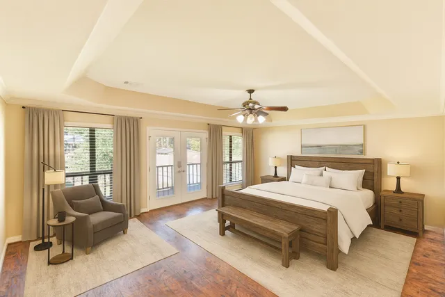 a bedroom with a bed couch chandelier and a window