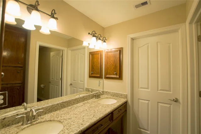 a bathroom with a granite countertop sink and a mirror