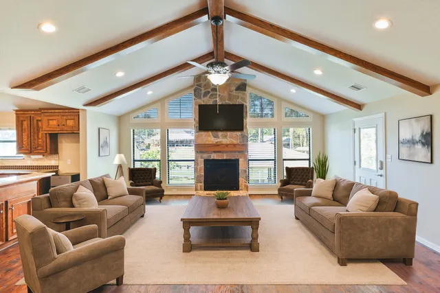 a living room with furniture fireplace and large windows