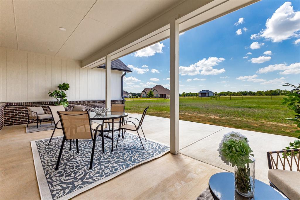 3150 Crisp Road Ennis, TX 75119 - Photo 23 of 30 Covered patio with a concrete surface, brick wainscoting, and white vertical siding