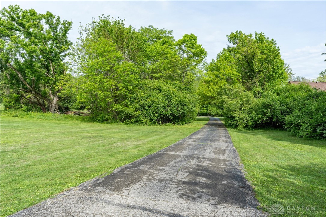 2165 Stewart Road Xenia, OH 45385 - Photo 50 of 59 A long paved driveway winds through lush greenery, offering a private approach to your home.