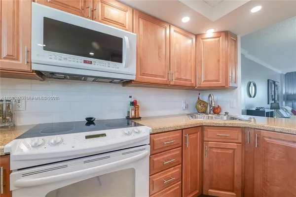 a kitchen with granite countertop stainless steel appliances and white cabinets