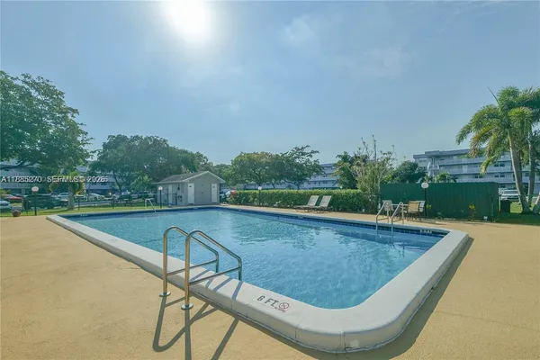 a view of swimming pool with a yard and green space